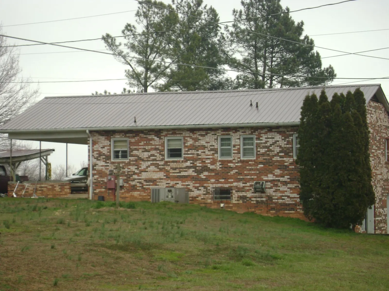 Gray metal roof on a brick split level home with a carport in Granite Falls