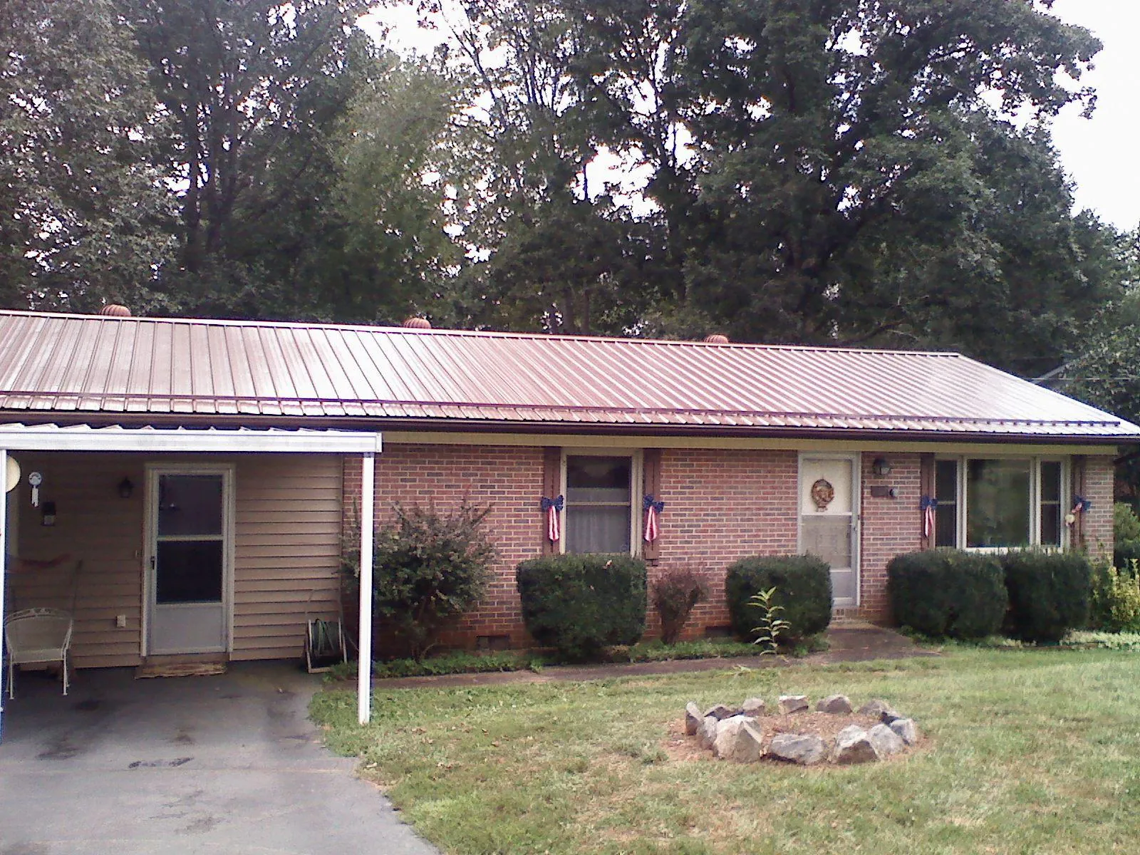Bronze metal roof and carport on a brick ranch home — Roof Repair work by our crew in Granite Falls